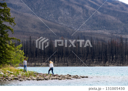 Mom and son at the lake among mountain peaks and burnt forest. Mom and son at the lake among mountain peaks and burnt forest. 131005430
