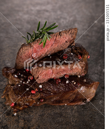 Beef rump steak on black stone table, top down, close-up. Beef rump steak on black stone table, top down, close-up. 131005531