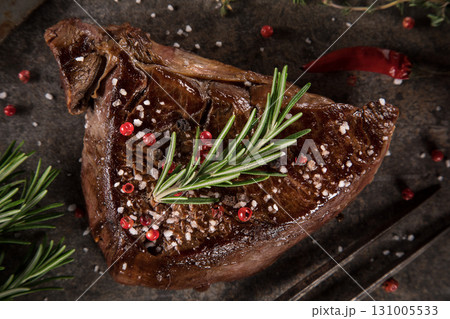 Beef rump steak on black stone table, top down, close-up. 131005533
