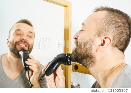 Man shaving trimming his beard 131005597
