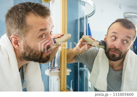 Man shaving trimming his beard Man shaving trimming his beard 131005600