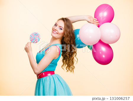 Woman with colorful balloons and lollipop 131006257