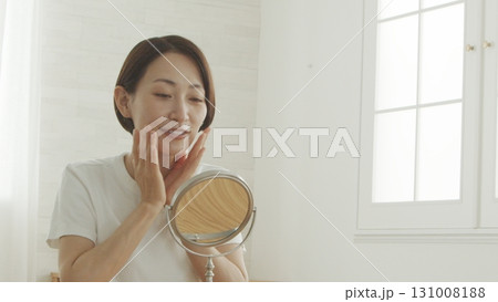 鏡の前で肌の調子を確認する40代の日本人女性 131008188