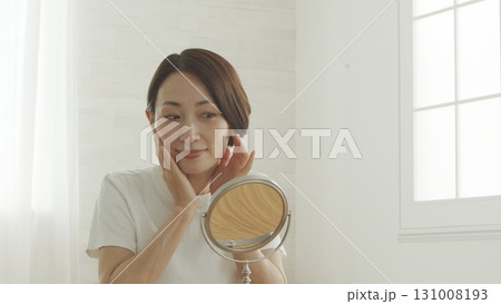 鏡の前で肌の調子を確認する40代の日本人女性 鏡の前で肌の調子を確認する40代の日本人女性 131008193