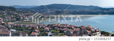 Hundreds harvest shellfish at low tide in a Galician estuary, seen from above. Hundreds harvest shellfish at low tide in a Galician estuary, seen from above. 131008257