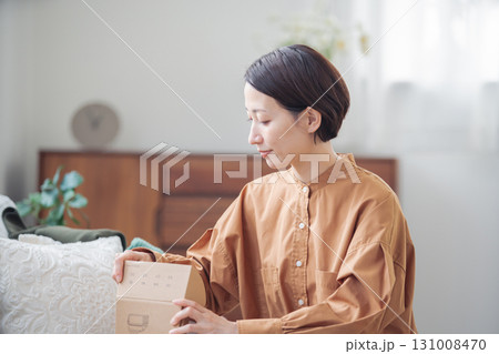 通販で購入した商品を持つ40代の日本人女性 131008470