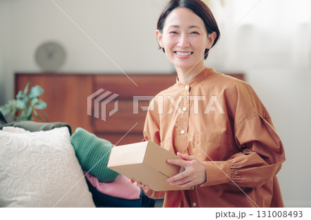 通販で購入した商品を持つ40代の日本人女性 131008493