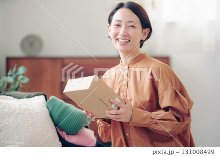 通販で購入した商品を持つ40代の日本人女性 131008499