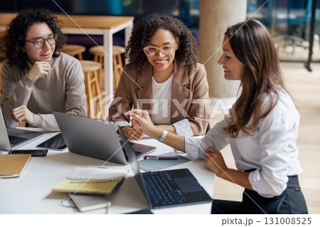 A group of diverse women engaging in collaboration within a thriving modern office environment A group of diverse women engaging in collaboration within a thriving modern office environment 131008525