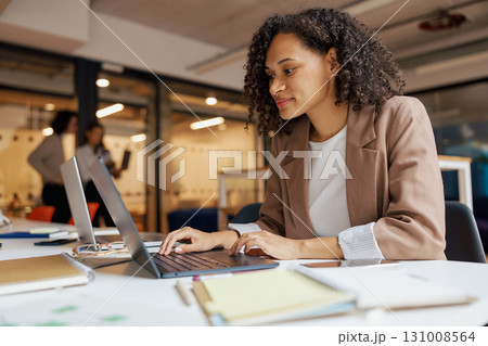 A Dedicated and Focused Professional Effectively Working at a Contemporary Office Desk Setup A Dedicated and Focused Professional Effectively Working at a Contemporary Office Desk Setup 131008564