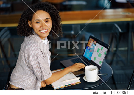 A Smiling Woman Working Enthusiastically on Her Laptop While Seated in a Cozy Cafe Environment A Smiling Woman Working Enthusiastically on Her Laptop While Seated in a Cozy Cafe Environment 131008612