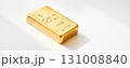 Gold bar resting on white surface with sunlight reflection Generative AI 131008840