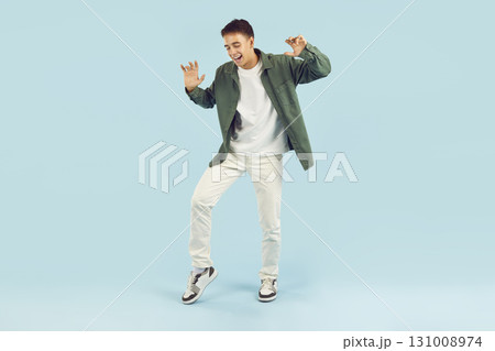 Young happy funny teenage boy having fun isolated on studio blue background. Young happy funny teenage boy having fun isolated on studio blue background. 131008974