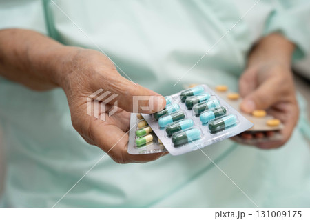 Asian elderly woman holding pill drug in hand, strong healthy medical concept. Asian elderly woman holding pill drug in hand, strong healthy medical concept. 131009175