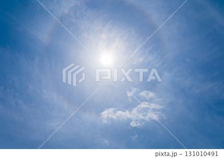 青空に流れる白い雲と太陽のハロ現象 131010491