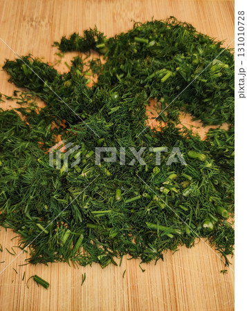 Freshly chopped dill resting on wooden cutting board Freshly chopped dill resting on wooden cutting board 131010728