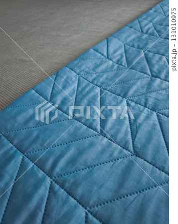 Soft blue blanket with chevron pattern on gray surface 131010975