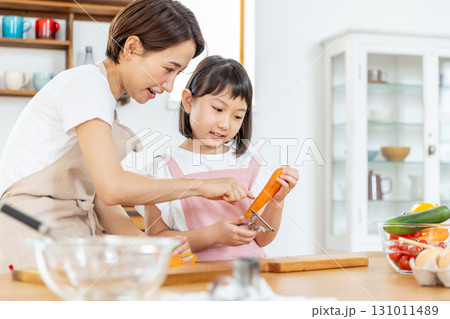 食事の手伝いをする小学生の女の子 131011489