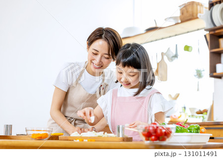 食事の手伝いをする小学生の女の子 131011491