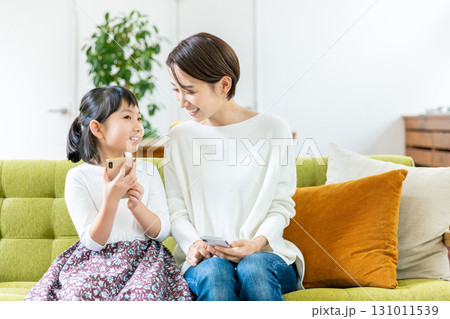スマホを見る子供とママ 131011539