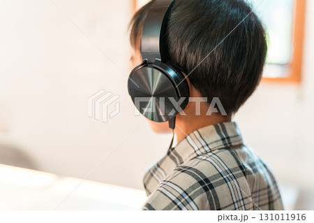 ヘッドホンをつけて大音量で音楽を聴く,ゲームをする子供の後ろ姿（ヘッドホン難聴,聴覚障害） 131011916