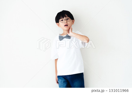 白い壁の前に立つ小学生の男の子 131011966
