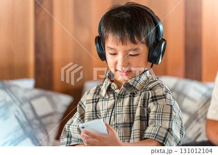 ヘッドホン・ヘッドセットをつけてゲームをする夢中な子供 ヘッドホン・ヘッドセットをつけてゲームをする夢中な子供 131012104