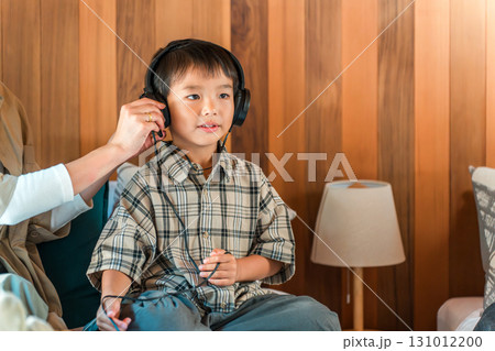 ヘッドホン・ヘッドセットをつけてゲームをする男の子と母親 ヘッドホン・ヘッドセットをつけてゲームをする男の子と母親 131012200