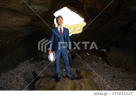 南の島の洞窟で太平洋戦争の慰霊をする遺族のスーツ姿の日本人シニア男性 131013127