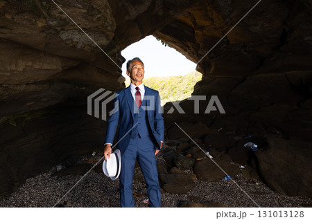 南の島の洞窟で太平洋戦争の慰霊をする遺族のスーツ姿の日本人シニア男性 南の島の洞窟で太平洋戦争の慰霊をする遺族のスーツ姿の日本人シニア男性 131013128