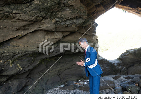 南の島の洞窟で太平洋戦争の慰霊をする遺族のスーツ姿の日本人シニア男性 南の島の洞窟で太平洋戦争の慰霊をする遺族のスーツ姿の日本人シニア男性 131013133