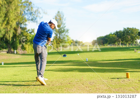 Asian male amateur golfer is enjoy playing golf at golf course in morning, he is showing his beautiful swing during tee off. Man playing golf. 131013287