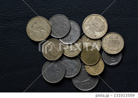 黒いレザーの上の旧スペインペソ硬貨 131013509