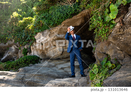 洞窟に立つスーツ姿の紳士 131013646