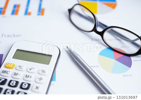 Eyeglass with calculator on chart graph paper. Finance, account, statistic, investment data economy, stock exchange business. 131013697