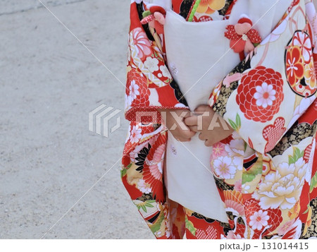七五三の伝統の和柄着物とお行儀良く重ね合わせた小さな両手 131014415