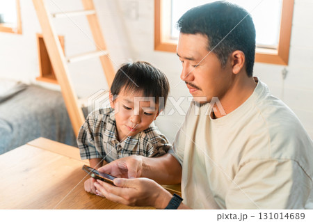 一緒にスマホで動画を見る,漫画を読む親子,パパ,子供 一緒にスマホで動画を見る,漫画を読む親子,パパ,子供 131014689