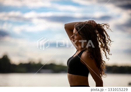 Stylized Silhouette of a Beautiful Woman with Curly Hair Against a Calm and Serene Background 131015229