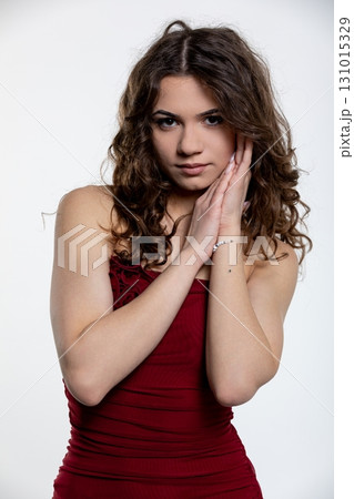 An Elegant Young Woman Posing Gracefully and Confidently in a Stunning Red Dress An Elegant Young Woman Posing Gracefully and Confidently in a Stunning Red Dress 131015329
