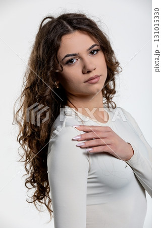 An Elegant Young Woman Dressed in a Sheer White Outfit, Featuring Beautiful Curls in Her Hair An Elegant Young Woman Dressed in a Sheer White Outfit, Featuring Beautiful Curls in Her Hair 131015330