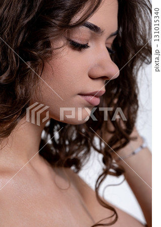 An Elegant and Artistic Profile Portrait of a Beautiful Young Woman with Curly Hair 131015340