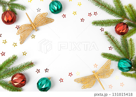Christmas card made of green Christmas tree branch, colorful tree balls, and shiny dragonfly decorations on gray background with space for text, invitations, greetings, advertisements, your design Christmas card made of green Christmas tree branch, colorful tree balls, and shiny dragonfly decorations on gray background with space for text, invitations, greetings, advertisements, your design 131015418