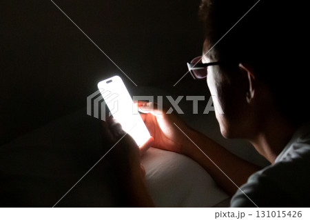 寝る前にベッドでスマホを使用、操作する人 寝る前にベッドでスマホを使用、操作する人 131015426