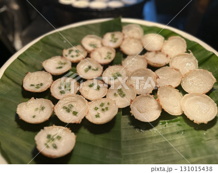 Small appetizers garnished with chives served on a green banana leaf Small appetizers garnished with chives served on a green banana leaf 131015438