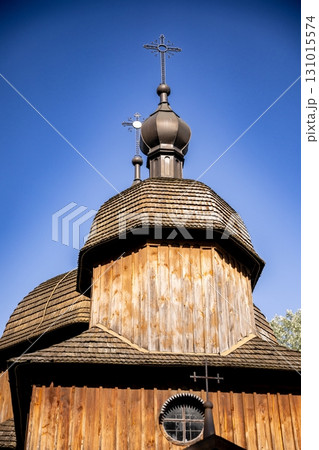 A traditional wooden church adorned with crosses set beautifully against the clear blue sky 131015574