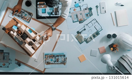 Manager writing idea on sticky notes while looking plan at tablet. Alimentation. 131015614