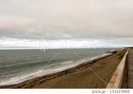 Ocean waves meeting sandy beach near wooden boardwalk Ocean waves meeting sandy beach near wooden boardwalk 131015666