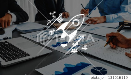 Business Team Collaborating on Growth Strategy with Documents and Laptop on Table Featuring Rocket Icon for Innovation Symbolism. Raster Business Team Collaborating on Growth Strategy with Documents and Laptop on Table Featuring Rocket Icon for Innovation Symbolism. Raster 131016119