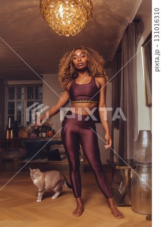 Stylish and Trendy Fitness Attire with an Adorable Cat Companion in a Modern Home Setting 131016310