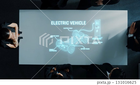 Innovative Electric Vehicle Presentation with Focus on Technology, Components, and Charging Stations Around Table in Modern Office Environment. Raster 131016625